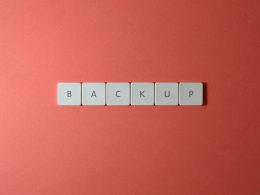 Free Close-up of keyboard keys spelling 'BACKUP' placed on a coral-colored surface. Stock Photo