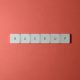 Free Close-up of keyboard keys spelling 'BACKUP' placed on a coral-colored surface. Stock Photo