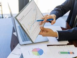 Free Business professionals discussing financial graphs and charts in an office setting. Stock Photo