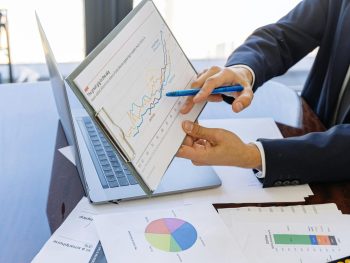 Free Business professionals discussing financial graphs and charts in an office setting. Stock Photo