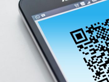 Free High-resolution close-up of a smartphone displaying a QR code on its screen. Stock Photo