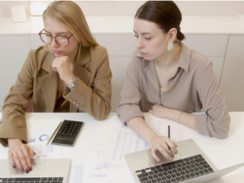 two women with laptops